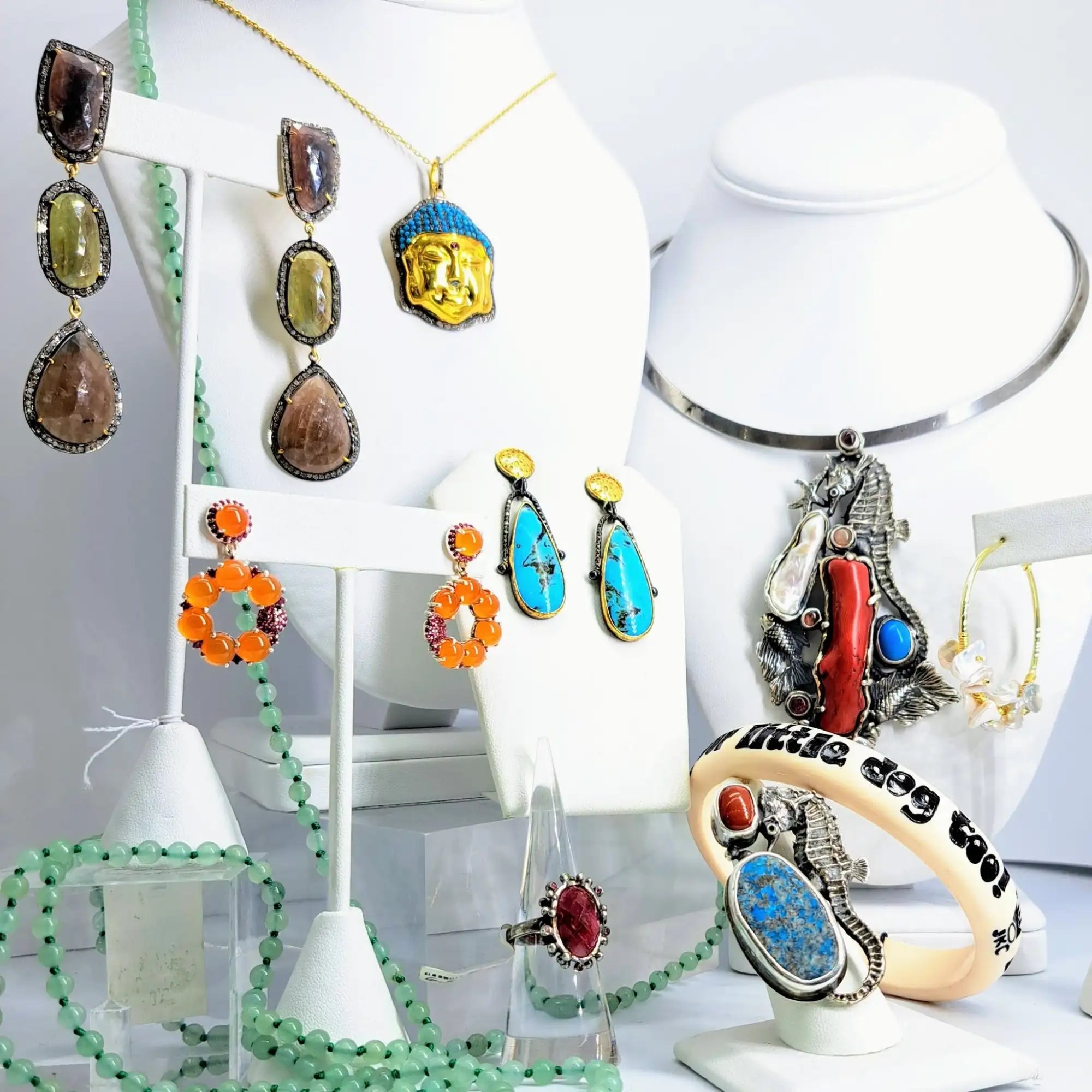 A turquoise and gold teardrop-shaped earring with a black metal frame.