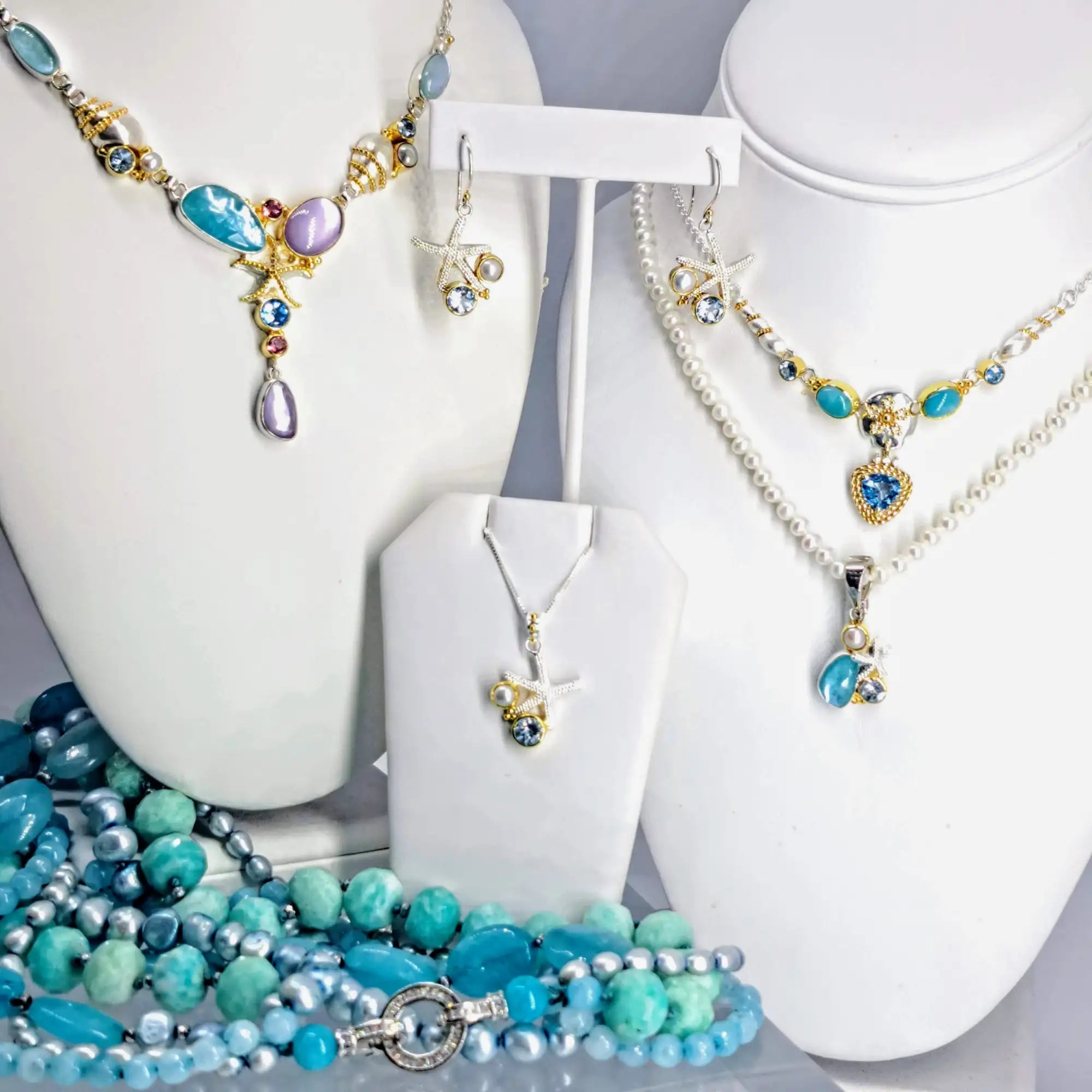 A vibrant turquoise and gold sea-themed necklace set featuring seashell, starfish, and gemstone accents.
